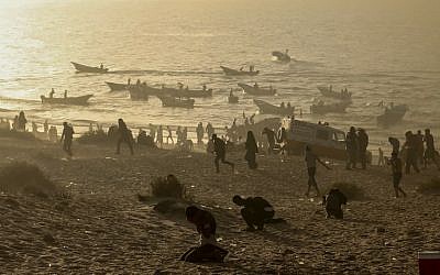 Palestinian protesters protect their faces from tear gas fired by Israeli troops during a demonstration on the beach near the maritime border with Israel, in Beit Lahia in the northern Gaza Strip, on October 29, 2018. (MAHMUD HAMS/AFP)