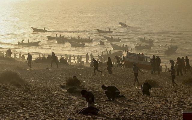 Palestinian protesters protect their faces from tear gas fired by Israeli troops during a demonstration on the beach near the maritime border with Israel, in Beit Lahia in the northern Gaza Strip, on October 29, 2018. (MAHMUD HAMS/AFP) Palestinian protesters protect their faces from tear gas fired by Israeli troops during a demonstration on the beach near the maritime border with Israel, in Beit Lahia in the northern Gaza Strip, on October 29, 2018. (MAHMUD HAMS/AFP)