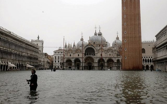 A man walks in the flooded St. Mark's Square during a high-water alert in Venice on October 29, 2018 (Photo by MIGUEL MEDINA / AFP) A man walks in the flooded St. Mark's Square during a high-water alert in Venice on October 29, 2018 (Photo by MIGUEL MEDINA / AFP)