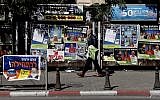 An Israeli man hangs campaign posters for local elections in the center of Jerusalem on October 30, 2018. (THOMAS COEX / AFP)
