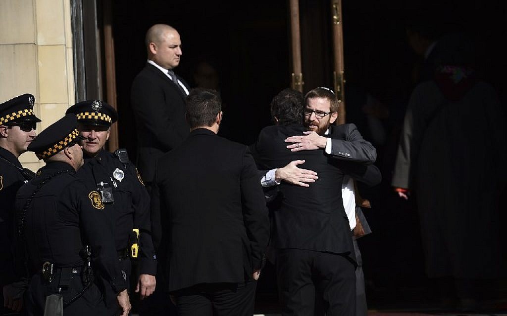 Men embrace outside the Rodef Shalom Congregation where the funeral for Tree of Life Congregation mass shooting victims Cecil Rosenthal and David Rosenthal who are brothers was held October 30, 2018 in Pittsburgh, Pennsylvania. (Brendan SMIALOWSKI / AFP)