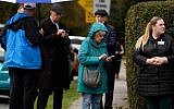 Residents check their phones near the site of a mass shooting at the Tree of Life Synagogue in the Squirrel Hill neighborhood on October 27, 2018 in Pittsburgh, Pennsylvania. (Jeff Swensen/Getty Images/AFP)