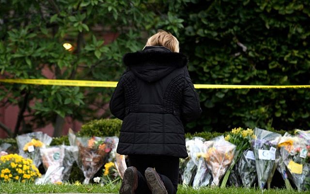 A mourner prays after laying flowers at the site of the mass shooting that killed 11 people and wounded 6 at the Tree Of Life Synagogue on October 28, 2018 in Pittsburgh, Pennsylvania. (Jeff Swensen/Getty Images/AFP) A mourner prays after laying flowers at the site of the mass shooting that killed 11 people and wounded 6 at the Tree Of Life Synagogue on October 28, 2018 in Pittsburgh, Pennsylvania. (Jeff Swensen/Getty Images/AFP)