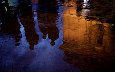 People are reflected in a puddle after attending a service at the Soldiers and Sailors Memorial Hall to honor and mourn the victims of Saturday's mass shooting at the Tree Of Life Synagogue on October 28, 2018 in Pittsburgh, Pennsylvania.  (Jeff Swensen/Getty Images/AFP)