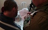 An IDF soldier notifying a relative of terror suspect Ashraf Na'alowa of the military's intention to demolish his home, October 15, 2018. (IDF Spokesperson's Unit)