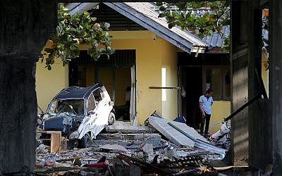 A man inspects his damaged home following a massive earthquake and tsunami at Talise beach in Palu, Central Sulawesi, Indonesia,  Oct. 1, 2018 (AP Photo/Tatan Syuflana)
