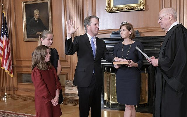 Retired Justice Anthony M. Kennedy, right, administers the Judicial Oath to Judge Brett Kavanaugh in the Justices' Conference Room of the Supreme Court Building. Ashley Kavanaugh holds the Bible. At left are their daughters, Margaret, background, and Liza. (Fred Schilling/Collection of the Supreme Court of the United States via AP) Retired Justice Anthony M. Kennedy, right, administers the Judicial Oath to Judge Brett Kavanaugh in the Justices' Conference Room of the Supreme Court Building. Ashley Kavanaugh holds the Bible. At left are their daughters, Margaret, background, and Liza. (Fred Schilling/Collection of the Supreme Court of the United States via AP)