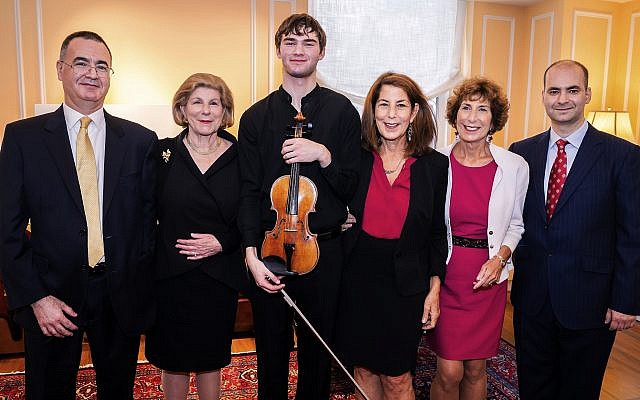 In this photo provided by Chris Lee, Juilliard student Nathan Meltzer, center, poses with the "Ames, Totenberg" Stradivari of 1734 violin loaned to him by the daughters of the late violinist Roman Totenberg, October 9, 2018 in New York. (Chris Lee via AP) In this photo provided by Chris Lee, Juilliard student Nathan Meltzer, center, poses with the "Ames, Totenberg" Stradivari of 1734 violin loaned to him by the daughters of the late violinist Roman Totenberg, October 9, 2018 in New York. (Chris Lee via AP)