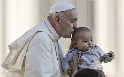Pope Francis kisses a child as he arrives with the popemobile in St.Peter's Square to held his weekly general audience at the Vatican, Wednesday, Oct. 10, 2018. (AP Photo/Gregorio Borgia)