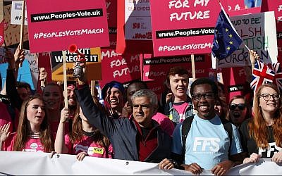 London Mayor Sadiq Khan, front center, holds a klaxon horn, as he joins protesters in the People's Vote March for the Future, in London, on October 20, 2018. (Yui Mok/PA via AP)