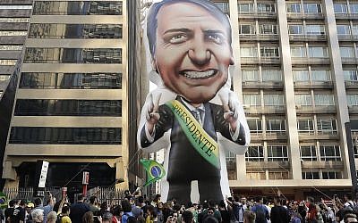 In this Sept. 9, 2018 file photo, supporters of presidential frontrunner Jair Bolsonaro, exhibit a large, inflatable doll in his image as they march along Paulista Avenue to show support for him in Sao Paulo, Brazil.  (AP Photo/Andre Penner)