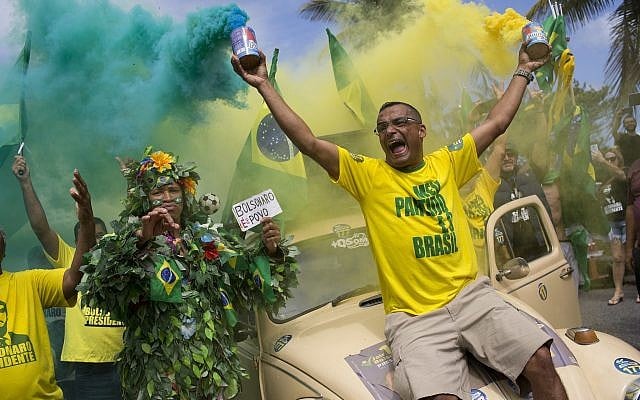 Supporters of presidential front-runner Jair Bolsonaro sing the national anthem outside his residence in Rio de Janeiro, Brazil, Sunday, Oct. 28, 2018, during the country's presidential runoff election.(AP Photo/Silvia Izquierdo) Supporters of presidential front-runner Jair Bolsonaro sing the national anthem outside his residence in Rio de Janeiro, Brazil, Sunday, Oct. 28, 2018, during the country's presidential runoff election.(AP Photo/Silvia Izquierdo)