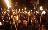 Members of the nationalist Svoboda (Freedom) party carry torches during a rally in Kiev, Ukraine, Jan. 29, 2017, to mark the anniversary of a battle near the town of Kruty (AP Photo/Sergei Chuzavkov)