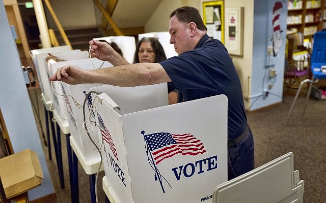 Election assistant Wayne Martin helps volunteers string lights as they set up voting booths at a polling station inside the library at Robert F. Kennedy Elementary School in Los Angeles on June 5, 2018 (AP Photo/Richard Vogel) Election assistant Wayne Martin helps volunteers string lights as they set up voting booths at a polling station inside the library at Robert F. Kennedy Elementary School in Los Angeles on June 5, 2018 (AP Photo/Richard Vogel)