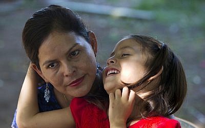 Araceli Ramos holds her 5-year-old daughter, Alexa, on her lap during an interview in a park in San Miguel, El Salvador, on August 18, 2018. (AP Photo/Rebecca Blackwell)