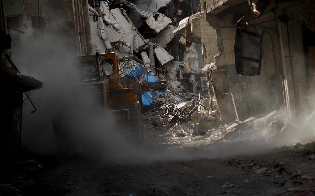 A bulldozer removes rubble from damage in street at the Palestinian refugee camp of Yarmouk in the Syrian capital Damascus, Syria, Saturday, Oct. 6, 2018 (AP Photo/Hassan Ammar)