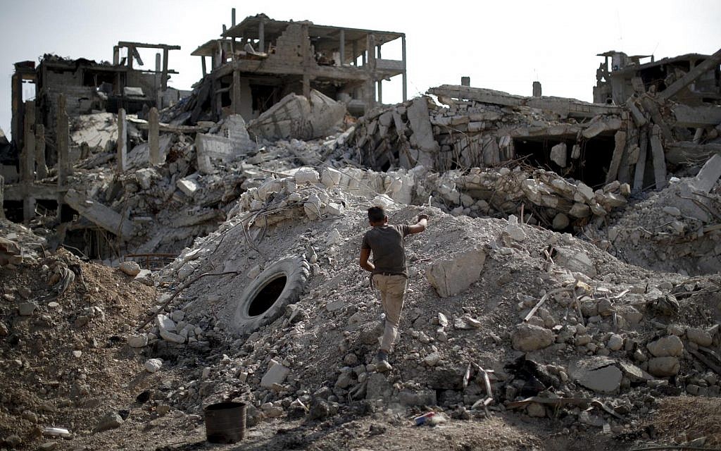 An young man walks through rubble in the Palestinian refugee camp of Yarmouk in the Syrian capital Damascus, Syria, Saturday, Oct. 6, 2018 (AP Photo/Hassan Ammar)