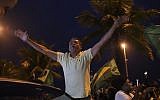 A supporter of Jair Bolsonaro, presidential candidate with the Social Liberal Party, celebrates in front of his house during the general elections in Rio de Janeiro, Brazil, Sunday, Oct. 7, 2018. (AP Photo/Ricardo Borges)