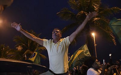 A supporter of Jair Bolsonaro, presidential candidate with the Social Liberal Party, celebrates in front of his house during the general elections in Rio de Janeiro, Brazil, Sunday, Oct. 7, 2018. (AP Photo/Ricardo Borges)