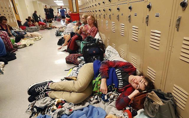 Emily Hindle lies on the floor at an evacuation shelter set up at Rutherford High School, in advance of Hurricane Michael, which is expected to make landfall today, in Panama City Beach, Fla., Wednesday, Oct. 10, 2018. (AP Photo/Gerald Herbert)