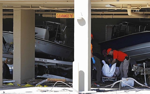 A body is removed after being discovered during the search of a housing structure in the aftermath of hurricane Michael in Mexico Beach, Florida, Oct. 12, 2018. (AP Photo/David Goldman)