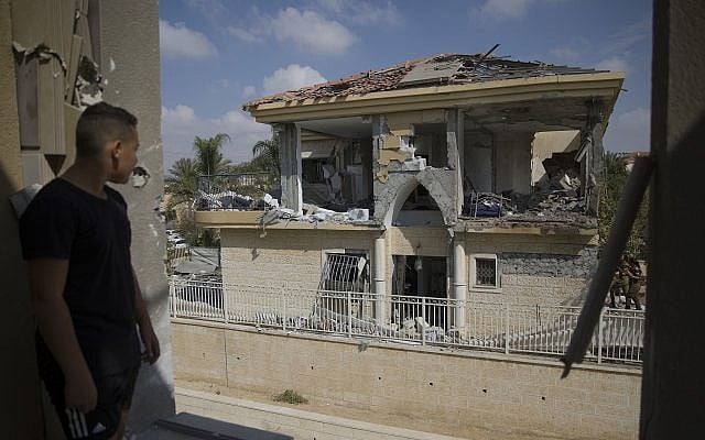 A man watches a house that was hit by a missile fired from Gaza Strip, in the city of Beersheba, southern Israel, Wednesday, Oct. 17, 2018. (AP/Tsafrir Abayov)