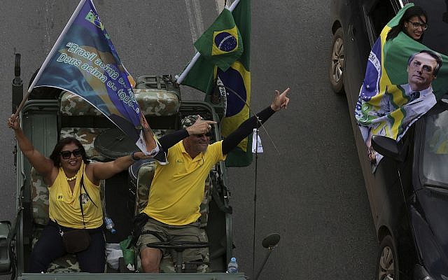 Making a gun sign with their hands, supporters parade in their cars during a rally in support of right-wing presidential candidate Jair Bolsonaro, in Brasilia, Brazil, October 27, 2018 (AP Photo/Eraldo Peres) Making a gun sign with their hands, supporters parade in their cars during a rally in support of right-wing presidential candidate Jair Bolsonaro, in Brasilia, Brazil, October 27, 2018 (AP Photo/Eraldo Peres)