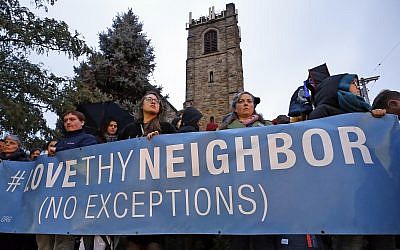 A group holds a sign in Squirrel Hill, Pittsburgh during a memorial vigil for the victims of the shooting at the Tree of Life Synagogue on October 27, 2018. (AP Photo/Gene J. Puskar)