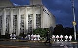 A Pittsburgh police officer walks past the Tree of Life synagogue and a memorial of flowers and stars in Pittsburgh, on October 28, 2018. (AP/Gene J. Puskar)