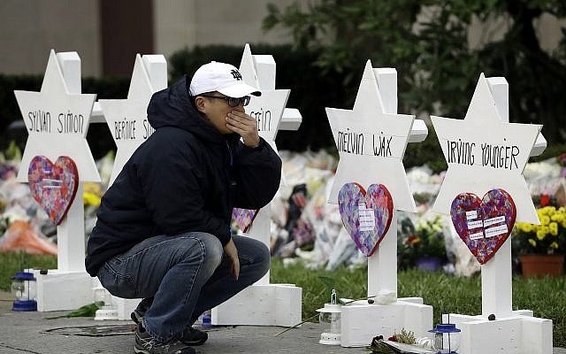 A person pauses in front of Stars of David with the names of those killed two days earlier in a deadly shooting at the Tree of Life Synagogue, in Pittsburgh, October 29, 2018. (Matt Rourke/AP) A person pauses in front of Stars of David with the names of those killed two days earlier in a deadly shooting at the Tree of Life Synagogue, in Pittsburgh, October 29, 2018. (Matt Rourke/AP)
