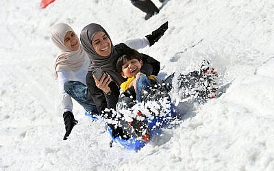 Tourists from Saudi Arabia enjoy a ride on a bob sled on the glacier of the Kitzsteinhorn mountain in Kaprun, in the Austrian province of Salzburg, Wednesday, June 10, 2015. (AP Photo/ Kerstin Joensson)