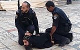 Israel Police officers restrain a Coptic cleric during a protest against safety maintenance work at the Church of the Holy Sepulchre in the Old City of Jerusalem, October 24, 2018. (Patriarchate of the Orthodox Copts in Jerusalem/Facebook)
