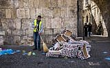 A municipality worker cleans garbage off the ground in the Muslim quarters of Jerusalem's Old City on March 4, 2016. (Corinna Kern/Flash90)