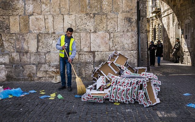 A municipality worker cleans garbage off the ground in the Muslim quarters of Jerusalem's Old City on March 4, 2016. (Corinna Kern/Flash90) A municipality worker cleans garbage off the ground in the Muslim quarters of Jerusalem's Old City on March 4, 2016. (Corinna Kern/Flash90)
