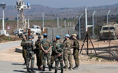 UN peacekeepers and Israeli soldiers are seen on the Israeli side of the Quneitra Crossing between Israel and Syria in the Golan Heights on September 27, 2018. (Basel Awidat/Flash90)