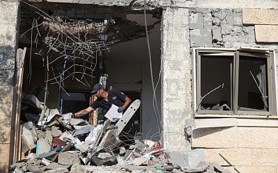 Israeli security forces inspect a building that was hit by a rocket fired from the Gaza Strip in the southern city of Beersheba on October 17, 2018. (Yonatan Sindel/Flash90)