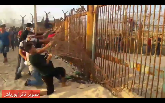 Palestinian rioters tear down a section of fencing around the northern Gaza border on October 8, 2018. (Screen capture: Quds News) Palestinian rioters tear down a section of fencing around the northern Gaza border on October 8, 2018. (Screen capture: Quds News)