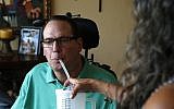 A man with multiple sclerosis gets help drinking water, August 21, 2015. (AP Photo/Brennan Linsley)