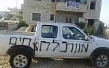 A car whose tires were slashed and was graffitied with the Hebrew phrase "death to the murderers" in the Palestinian village of Asira al-Qabaliya on October 15, 2018. (Said Shartah)