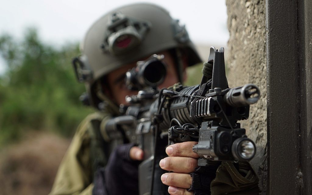 An Israeli soldier aims his gun during operations in the northern West Bank village of Shuweika on October 7, 2018. (Israel Defense Forces)
