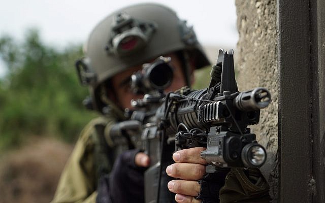 An Israeli soldier aims his gun during operations in the northern West Bank village of Shuweika on October 7, 2018. (Israel Defense Forces)