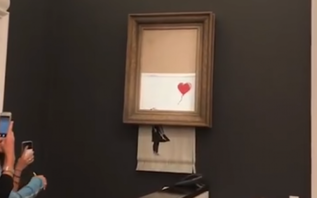 Banky artwork self destructs at London auction house, October 5, 2018 (YouTube screenshot) Banky artwork self destructs at London auction house, October 5, 2018 (YouTube screenshot)
