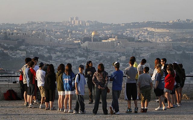 A tour group listens to a guide at the Armon Hanatziv Promenade in Jerusalem against the backdrop of the Old City in 2018 (Miriam Alster/Flash90) A tour group listens to a guide at the Armon Hanatziv Promenade in Jerusalem against the backdrop of the Old City in 2018 (Miriam Alster/Flash90)