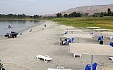 People sit on the beach of the Sea of Galilee near Kibbutz Ein-Gev, on October 8, 2018. (JACK GUEZ/AFP)