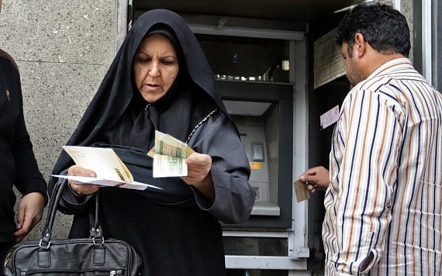 People withraw money from an ATM in Tehran's grand bazaar on November 3, 2018. (ATTA KENARE / AFP)