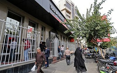 Iranians walk past a bank in the capital Tehran on November 3, 2018. (ATTA KENARE / AFP)