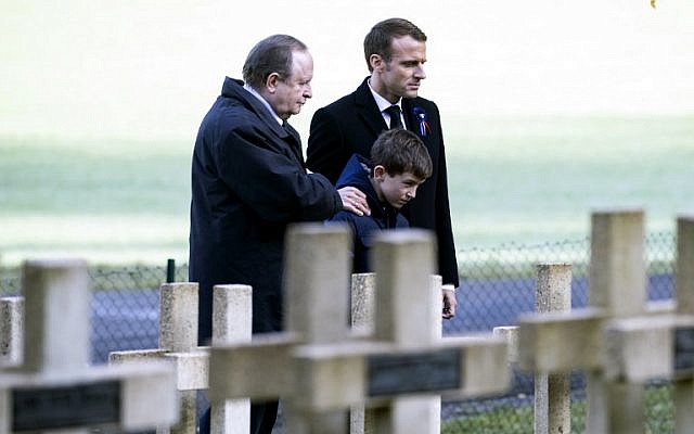 French president Emmanuel Macron, right, and relatives of Lieutenant Robert Porchon, brother-in-arms of French writer Maurice Genevoix killed during World War I, pay their respects by his tomb at the Trottoir necropolis in Les Eparges, in Meuse region, Eastern France, on Novembre 6, 2018. (Etienne LAURENT/POOL/AFP)