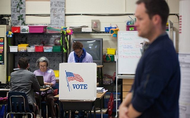 Election workers assist would-be voters at First Ward Creative Arts Academy on November 6, 2018 in Charlotte, North Carolina. (Logan Cyrus / AFP)