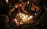 People light candles on November 8, 2018 at the site of a former synagogue in Schwerin as Germany marks the 80th anniversary of the 'Night of Broken Glass' (Kristallnacht) on November 9, 1938. (Bernd Wuestneck/dpa/AFP)