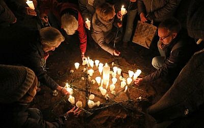 People light candles on November 8, 2018 at the site of a former synagogue in Schwerin as Germany marks the 80th anniversary of the 'Night of Broken Glass' (Kristallnacht) on November 9, 1938. (Bernd Wuestneck/dpa/AFP)